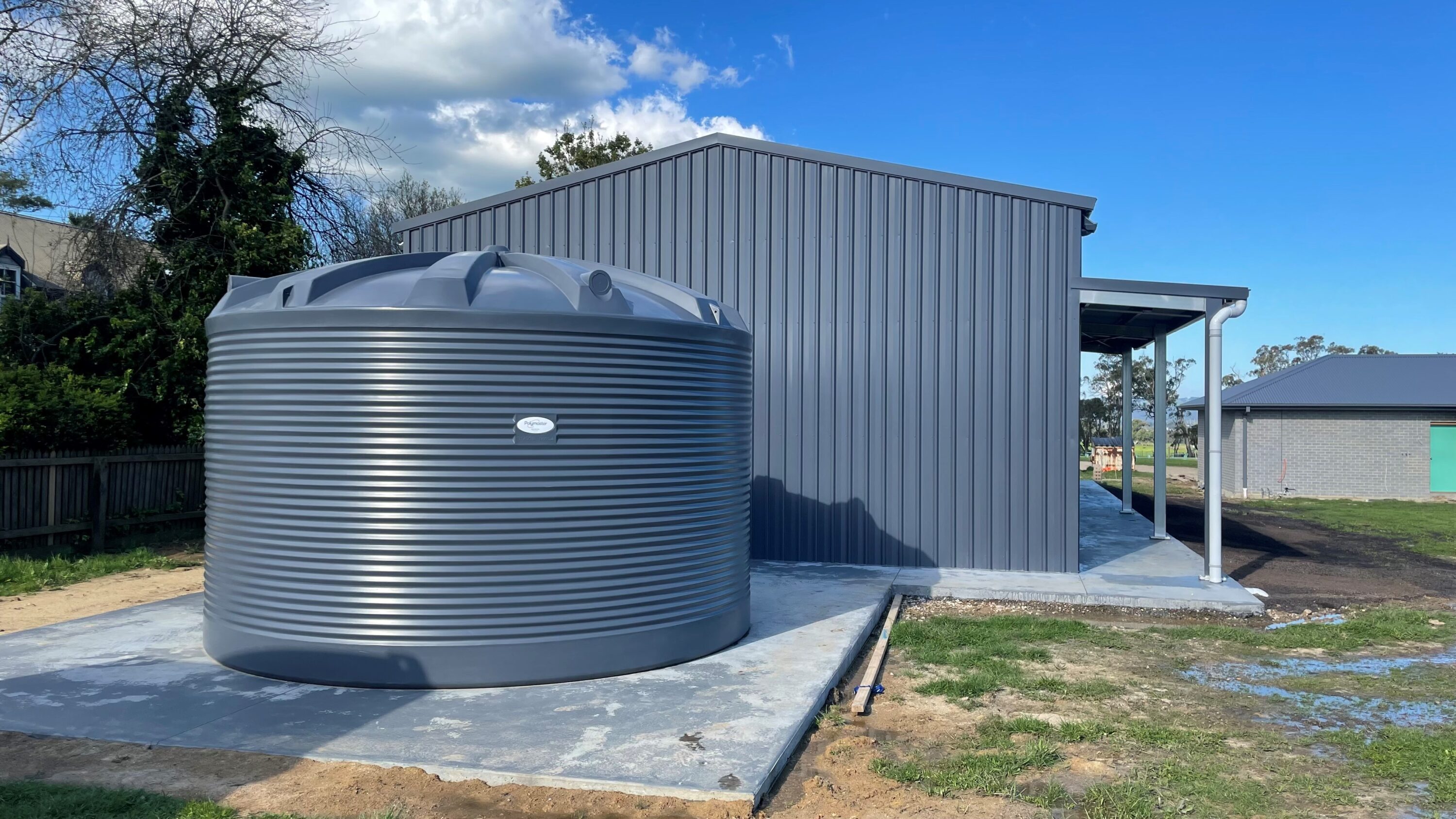 Poly water tank beside shed