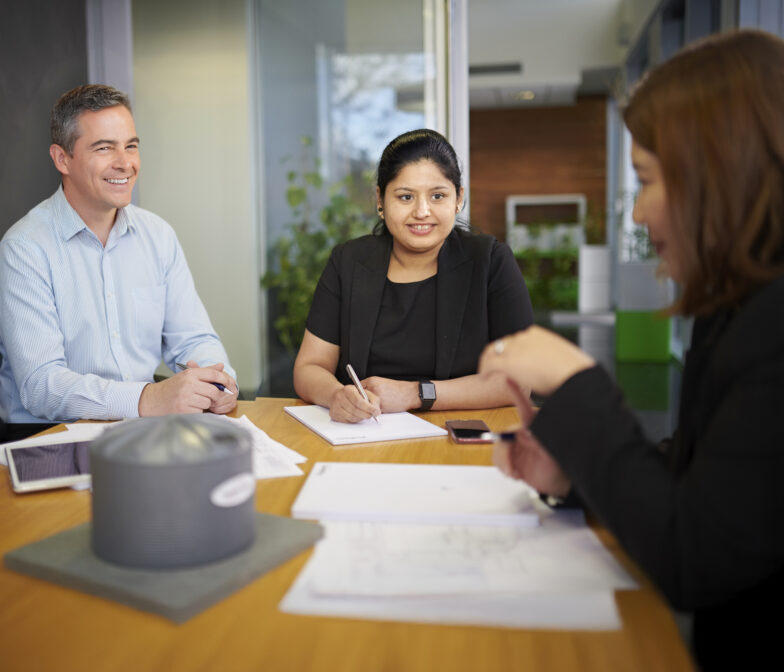 Polymaster team members in an office meeting with a water tank sample on the table