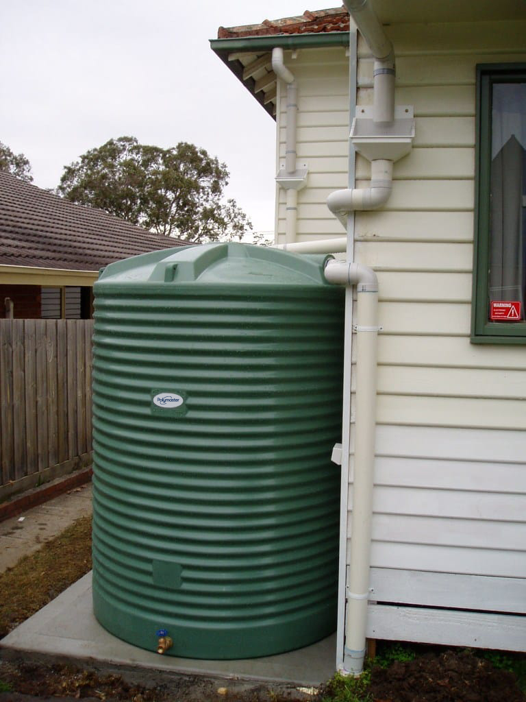 small tall water tank installed beside a residential home
